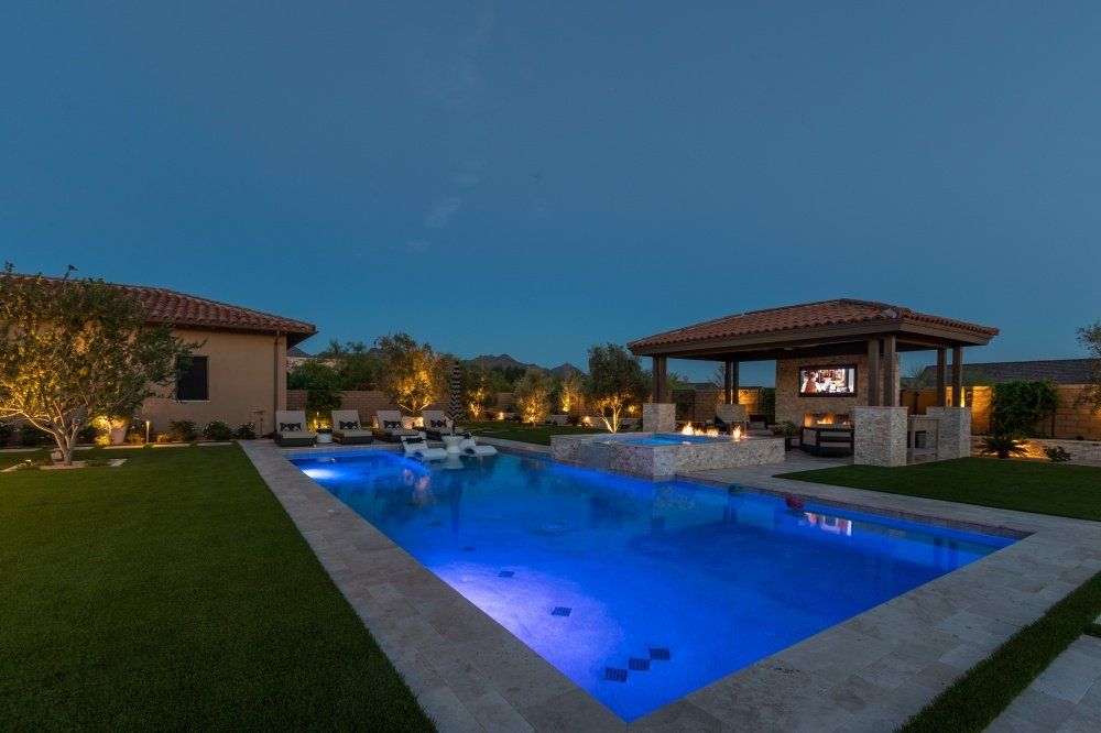 There is a large swimming pool in the backyard of a house.