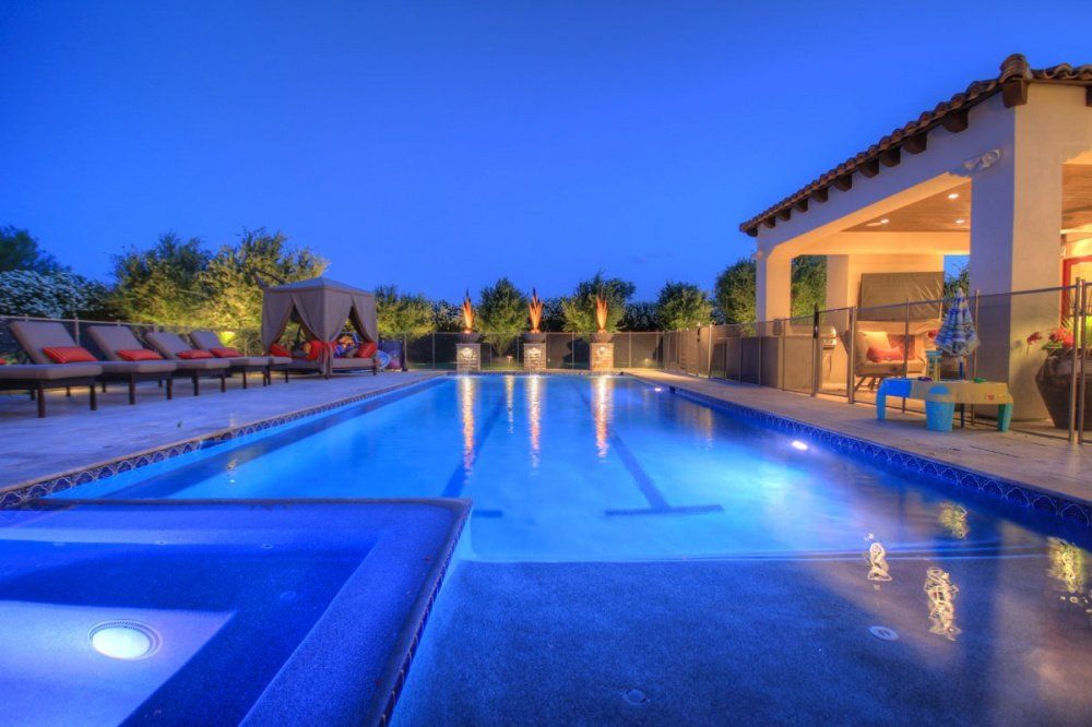 A large swimming pool is lit up at night.