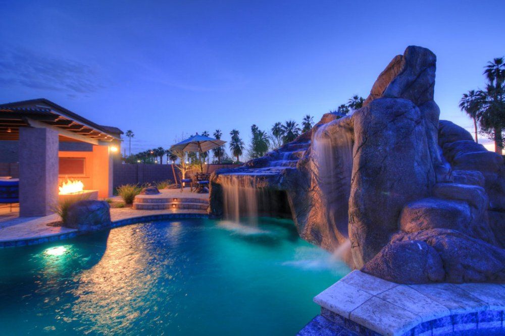 A large swimming pool with a waterfall in the middle of it