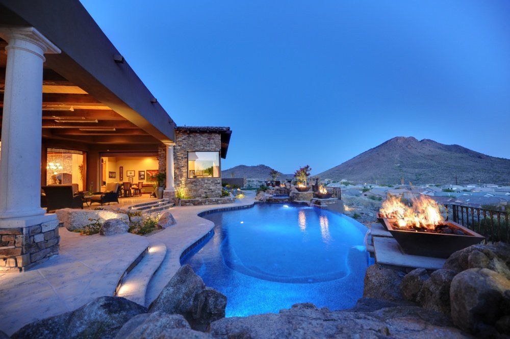 A large house with a swimming pool and a fire pit