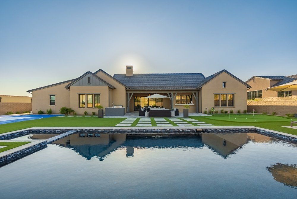 A large house with a large swimming pool in front of it.