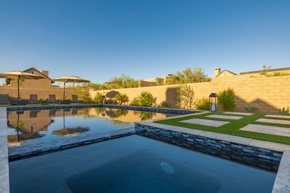 There is a large swimming pool in the backyard of a house.