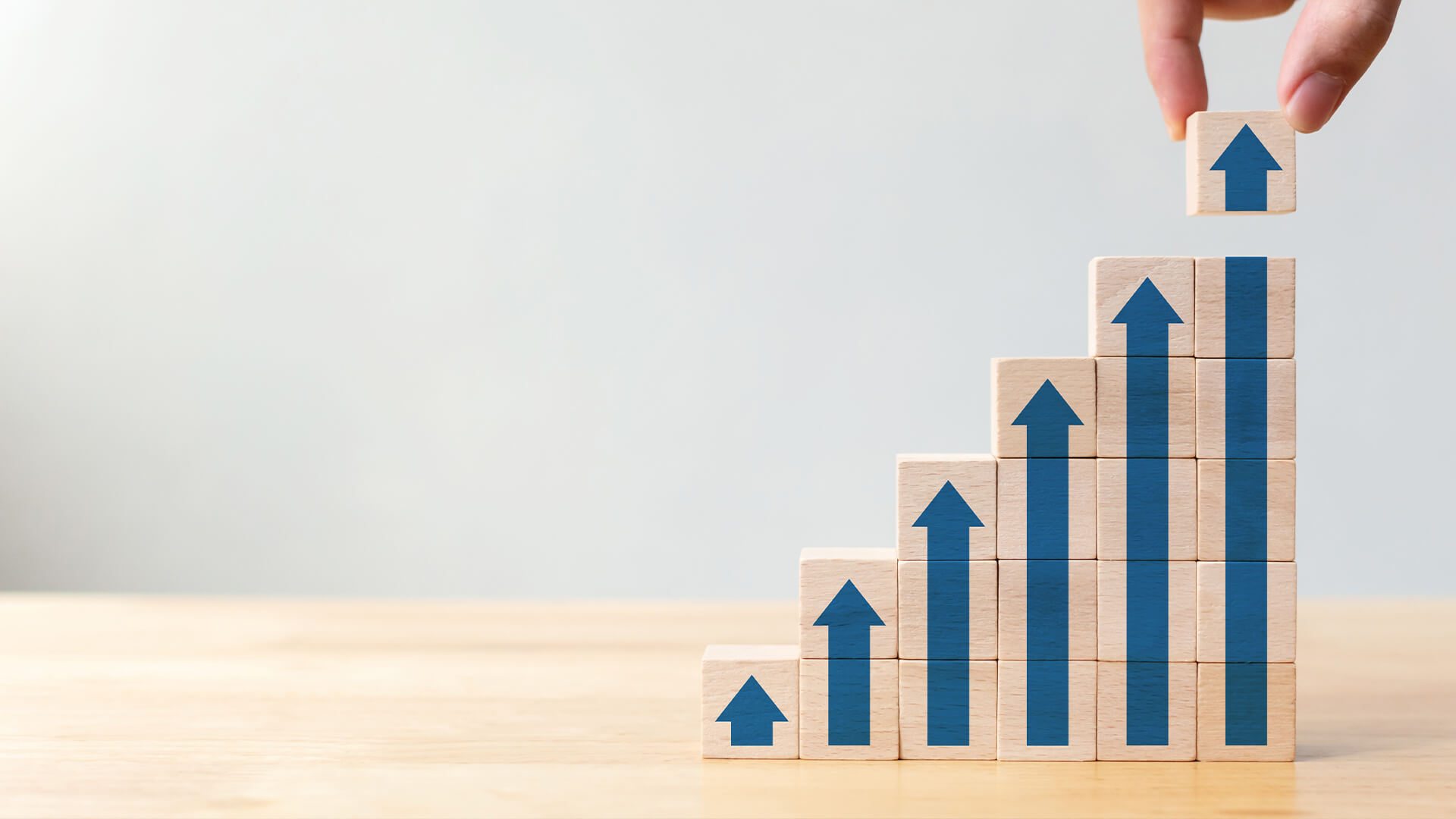 Image of a person stacking blocks like a stock chart