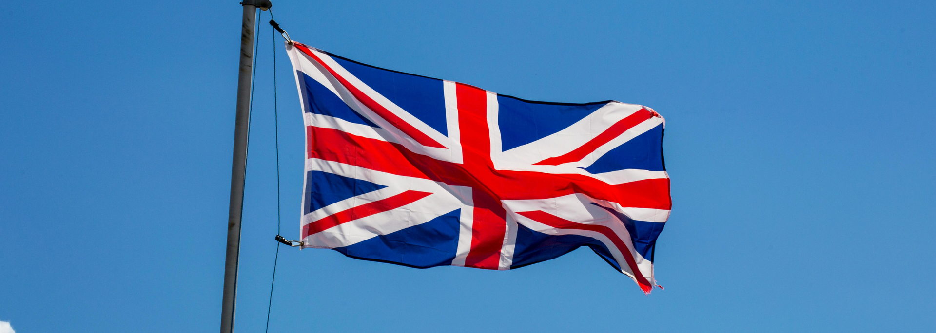Picture of a British flag flying on a flagpole.