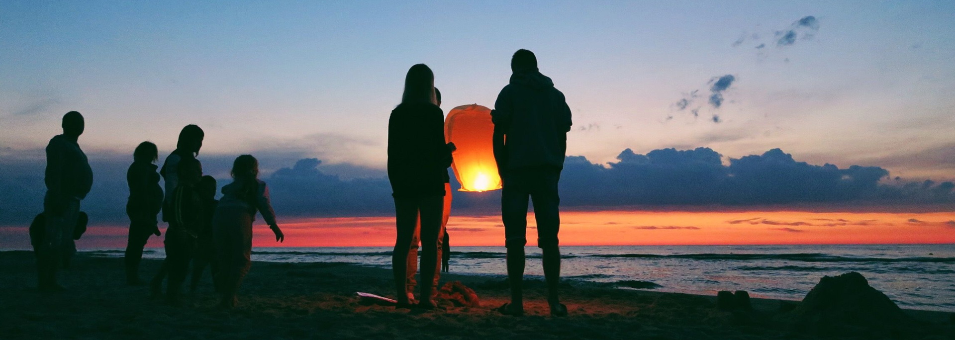 Picture of people stood by the sea. 