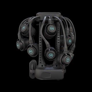 Black over-ear headphones arranged on a compact charging stand against a dark background