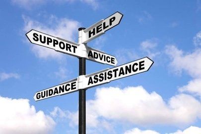 Signpost with arrows labeled support, help, advice, guidance, and assistance against a blue sky