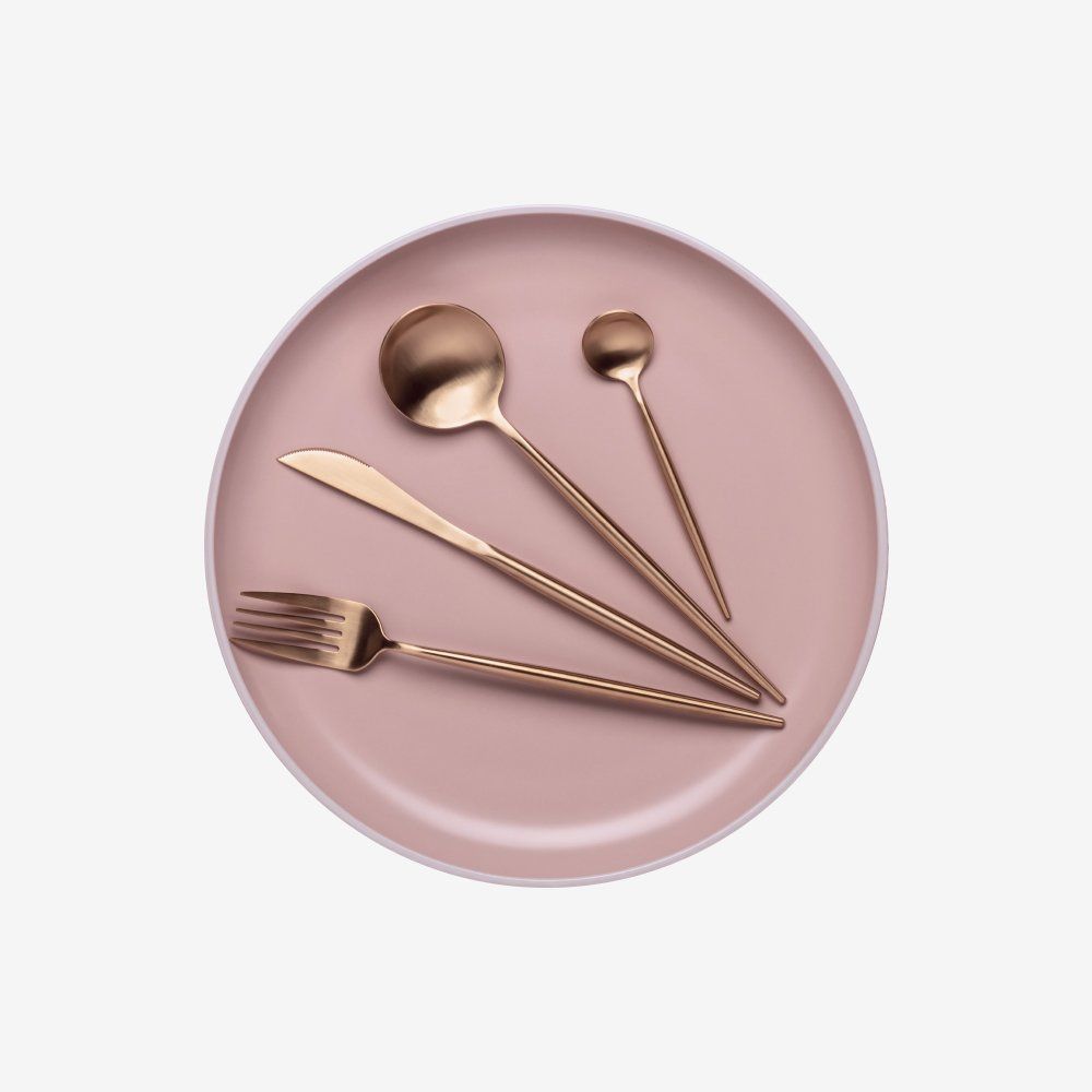 Rose-gold spoon, fork, knife, and tablespoon lined up on a white background