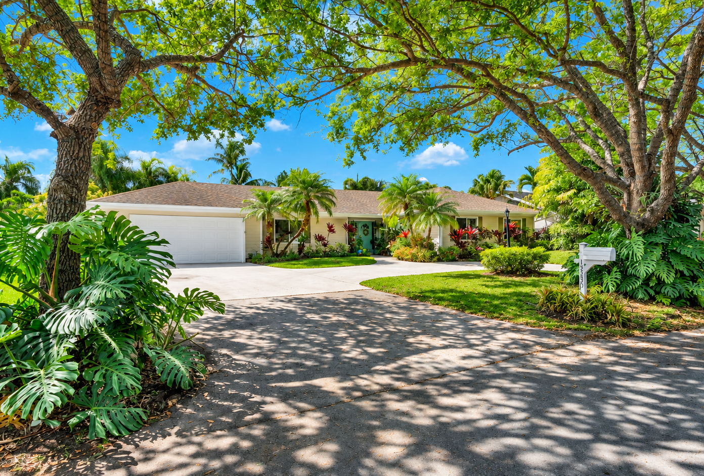Hand holding house keys in front of a modern home for sale