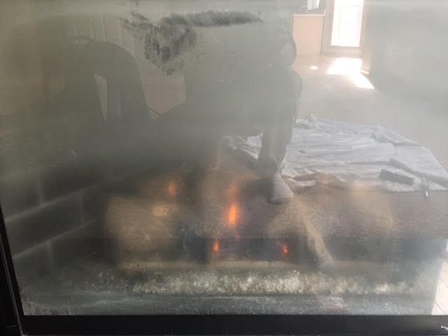 An old fireplace in an abandoned building with a hole in the wall.