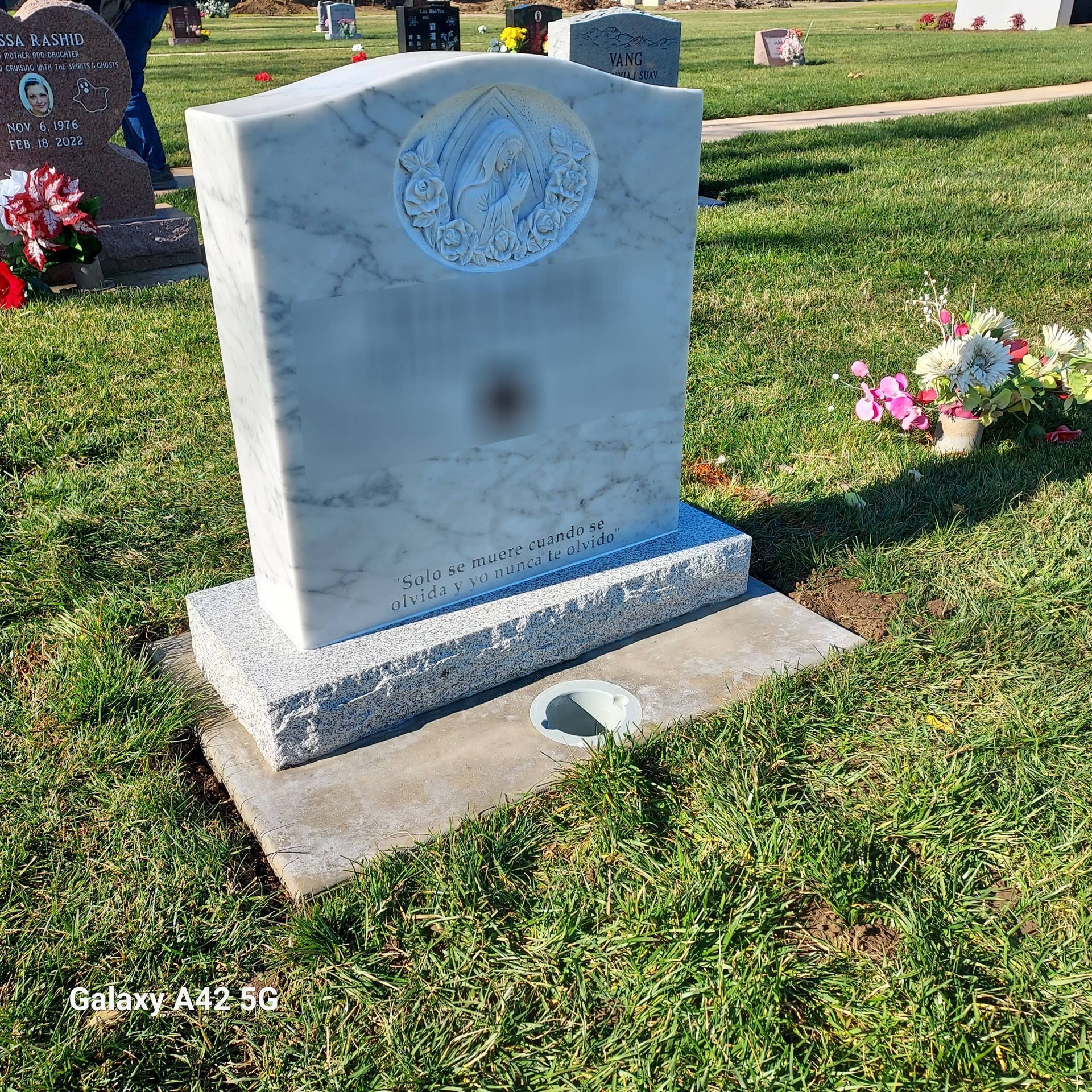A grave with flowers on it in a cemetery.