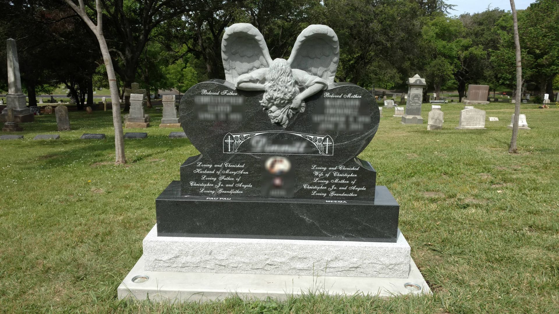 A gravestone with a wreath on top of it in a cemetery.