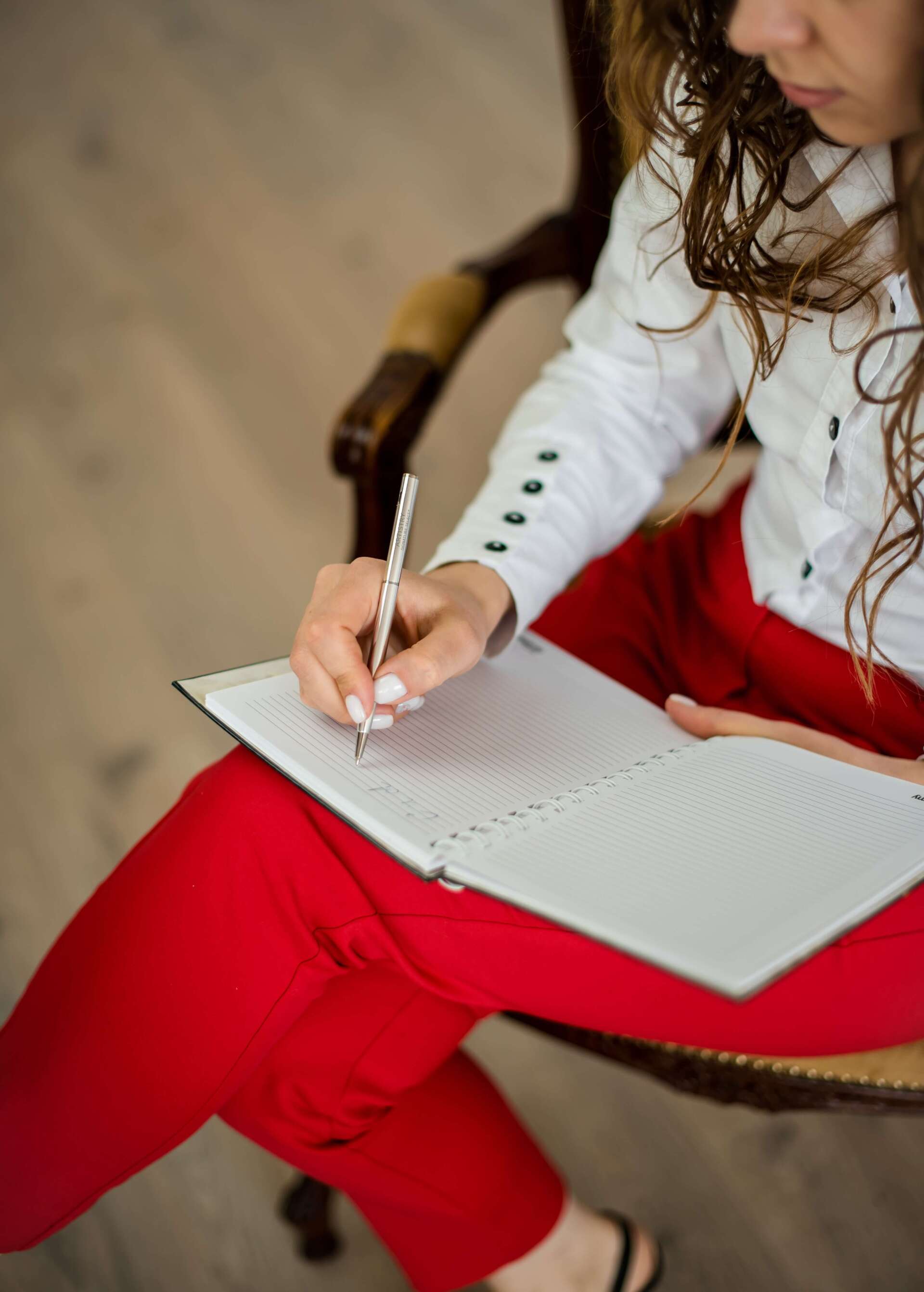 woman sitting on chair writing funeral planning in Winnipeg