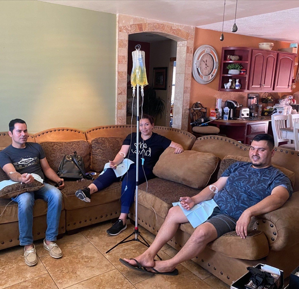 Three people are sitting on a couch in a living room
