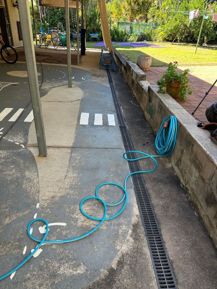 Blue Hose Lies Coiled on a Paved Outdoor Area — I Do It All in Caloundra, QLD