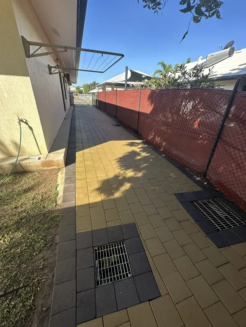 Paved Walkway Runs Between a Yellow House Wall— I Do It All in Nambour, QLD