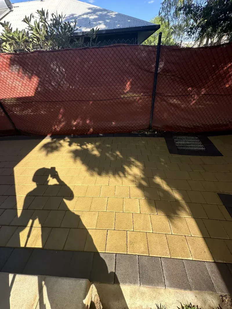 Shadow of a Person Holding a Phone Over a Paved Patio — I Do It All in Buderim, QLD