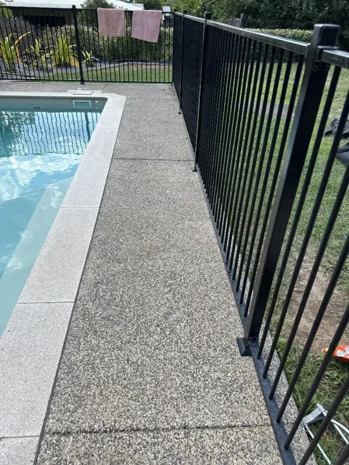 Black Metal Fence Runs Alongside a Pool Deck — I Do It All in Buderim, QLD
