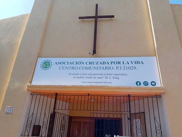 Church entrance with a cross and Spanish sign reading “Asociación Cruzada por la Vida”