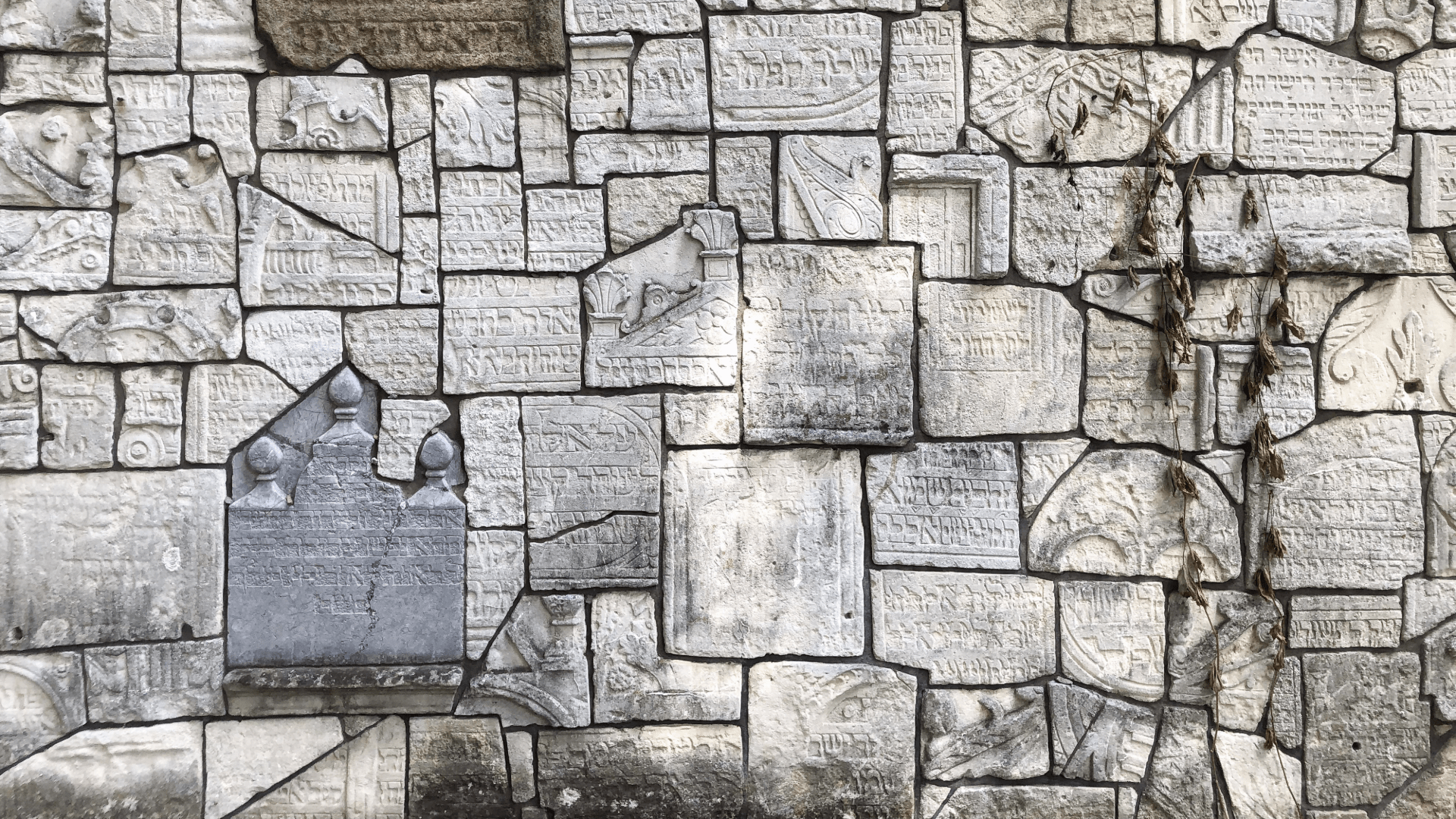Memorial plaque set into cracked stone pavement at Kraków’s Plaszów camp.