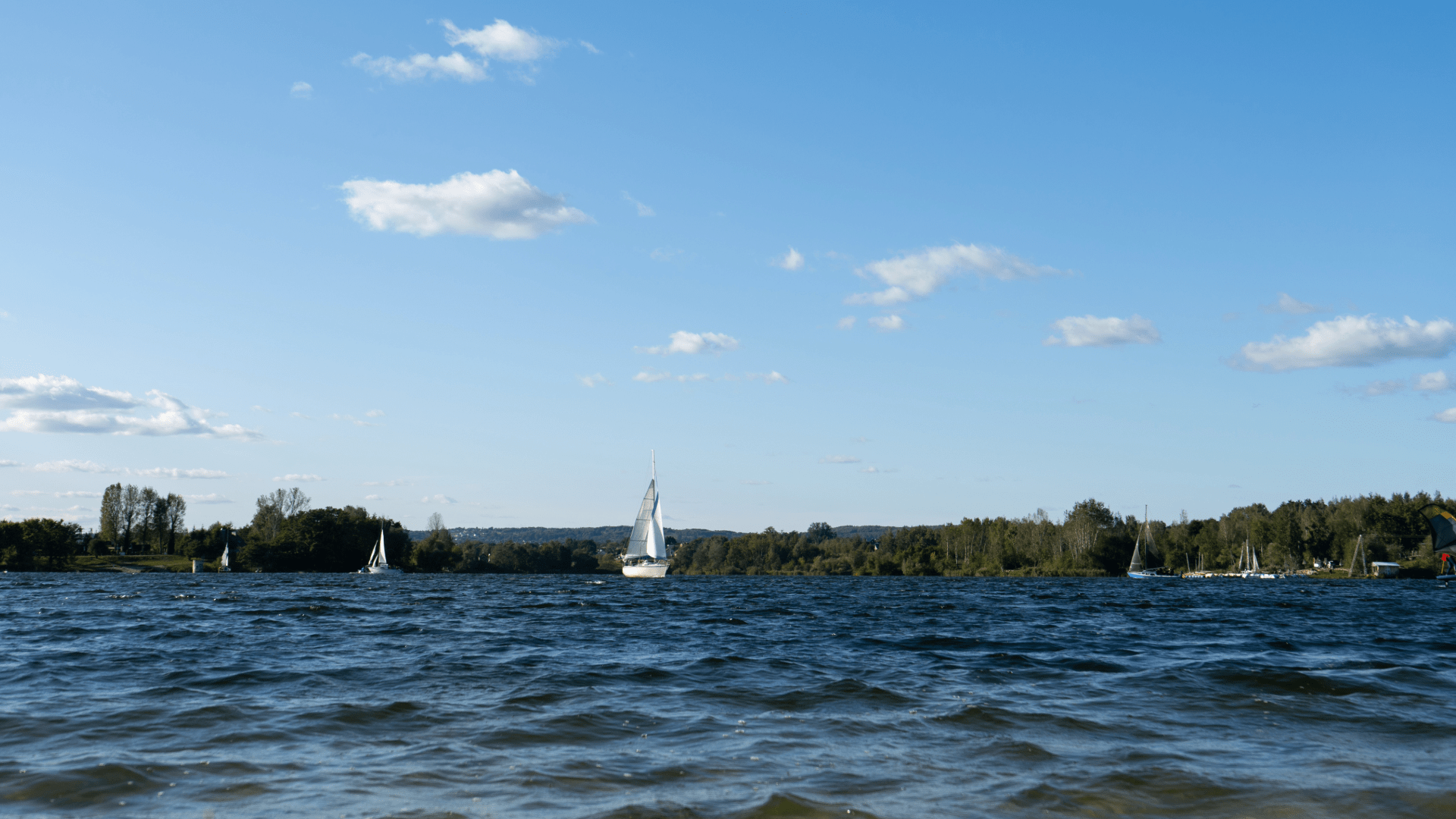 Aerial view of an outdoor lake with people engaged in kayaking and sailing