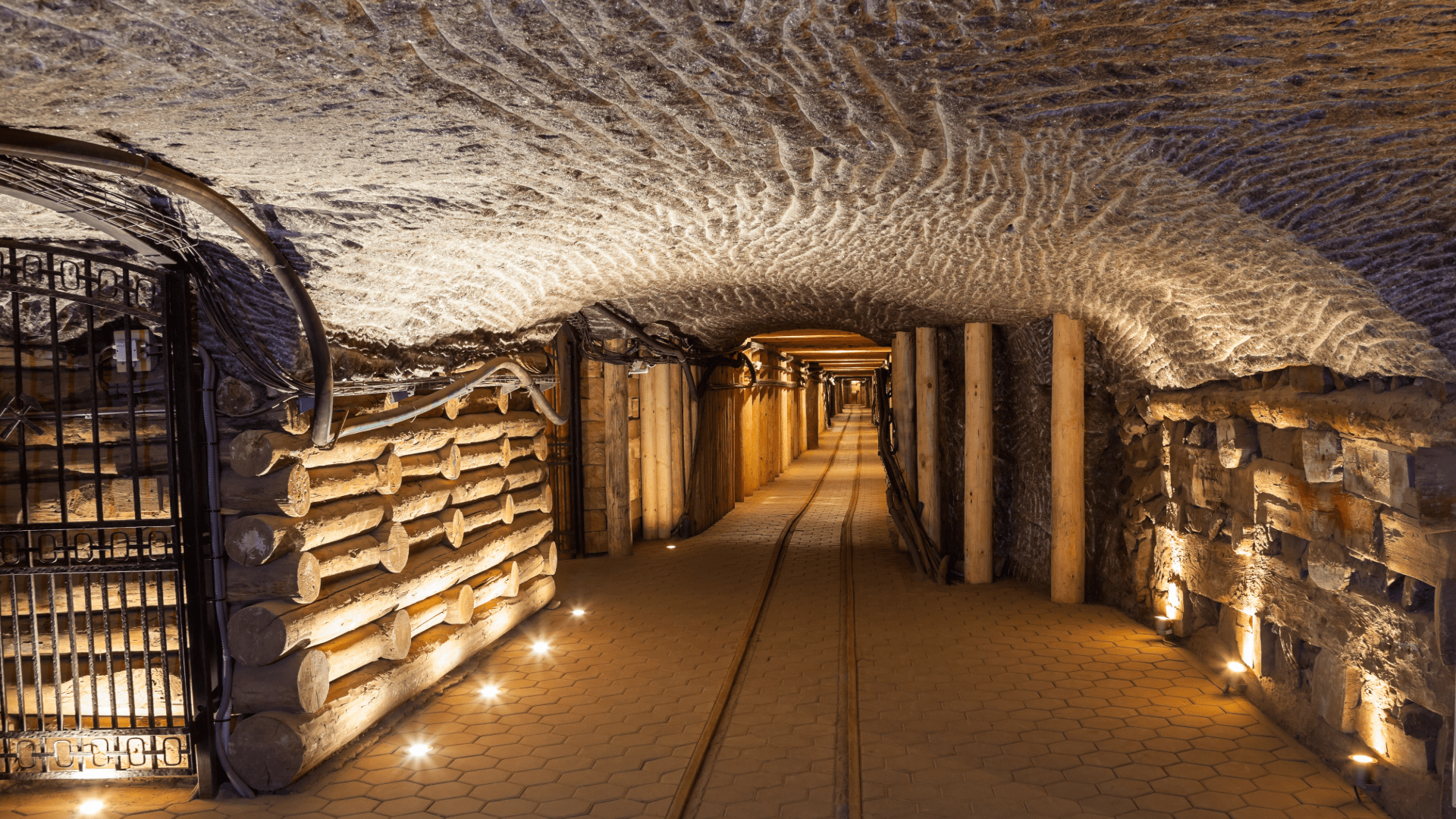 Salt mine corridor with carved walls, support beams, and warm lighting.
