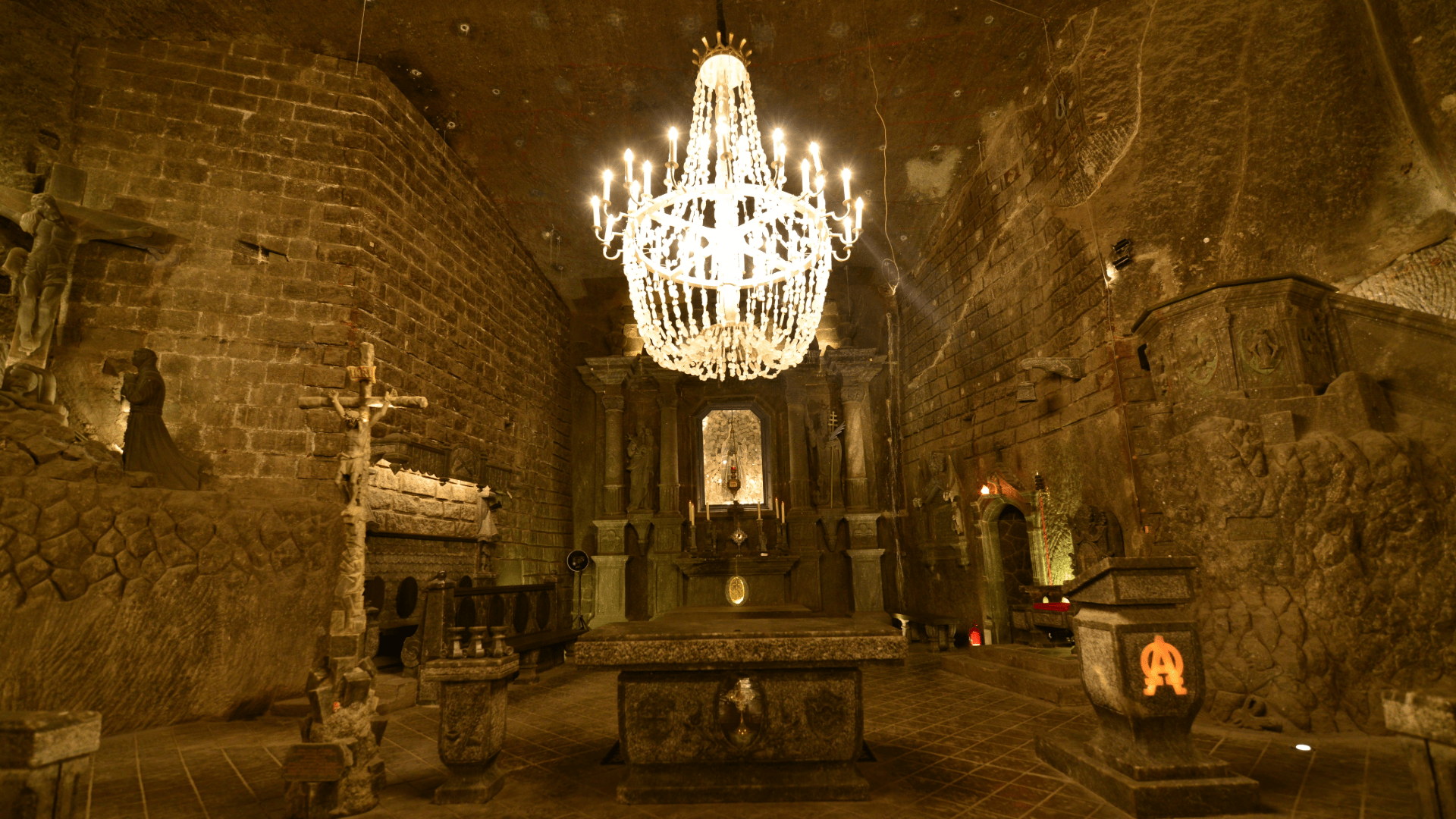 Ornate underground chapel in Wieliczka Salt Mine with a glowing chandelier.