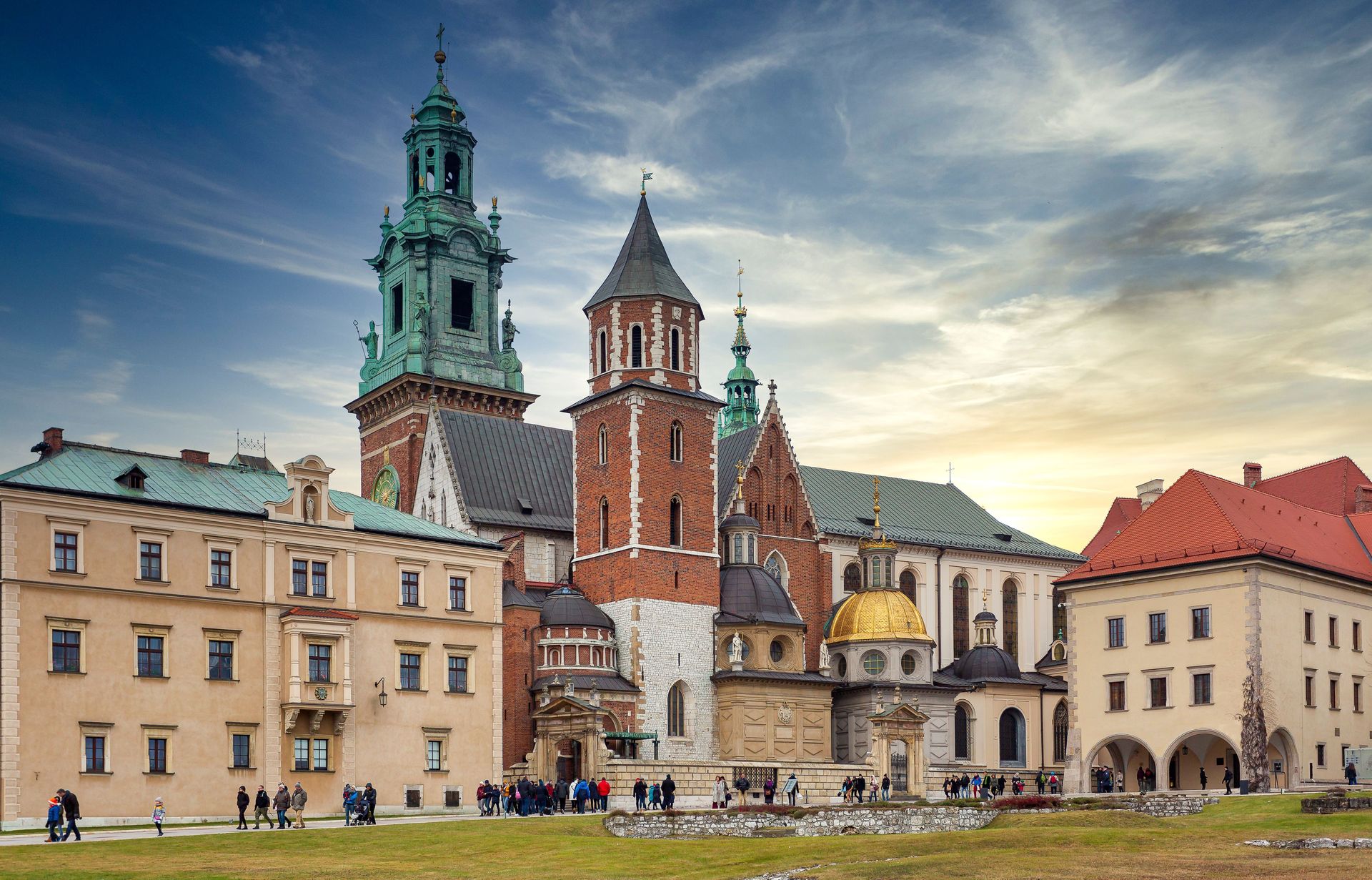 Krakow Old Town skyline at sunrise with church towers in silhouette.
