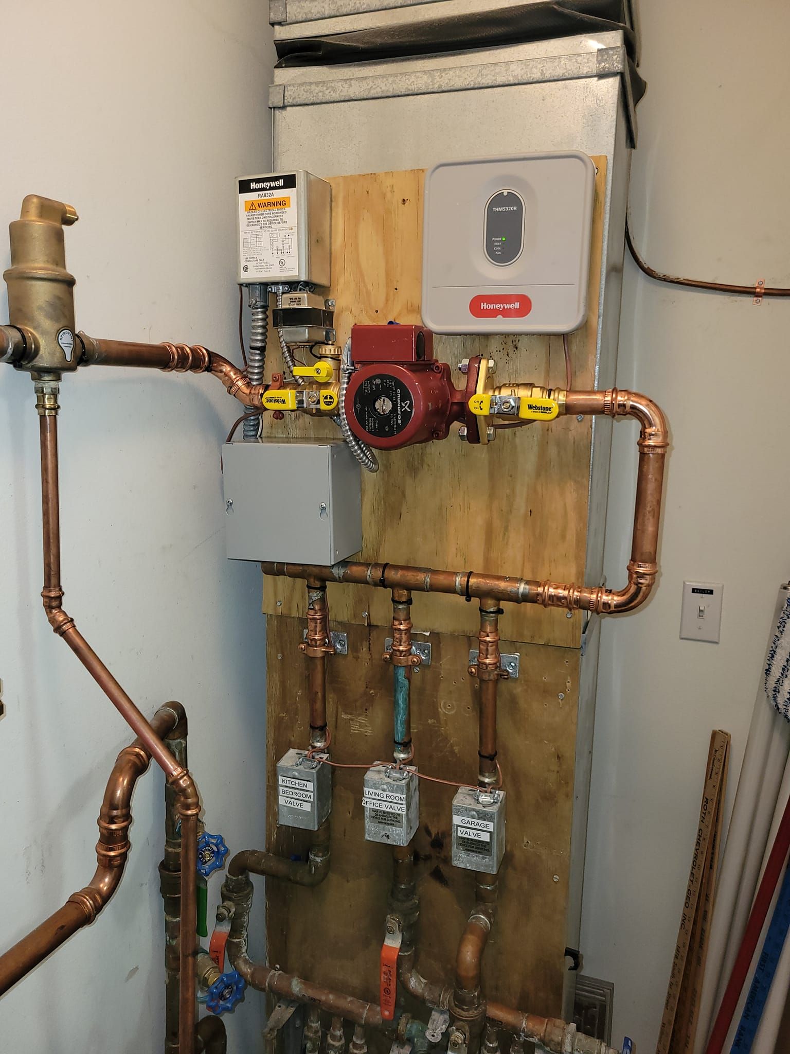 A room with copper pipes and a pump on the wall