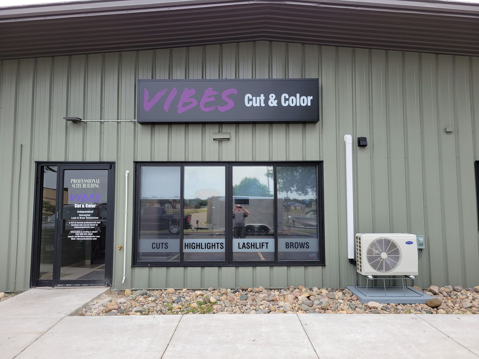 A green building with a sign that says vibes cut & color