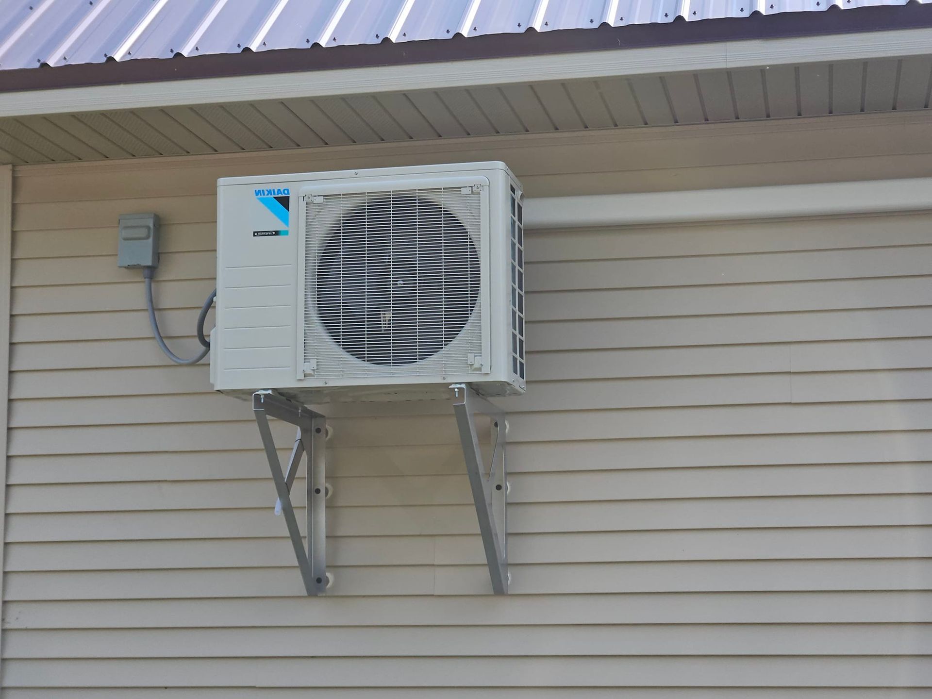 A daikin air conditioner is mounted on the side of a house