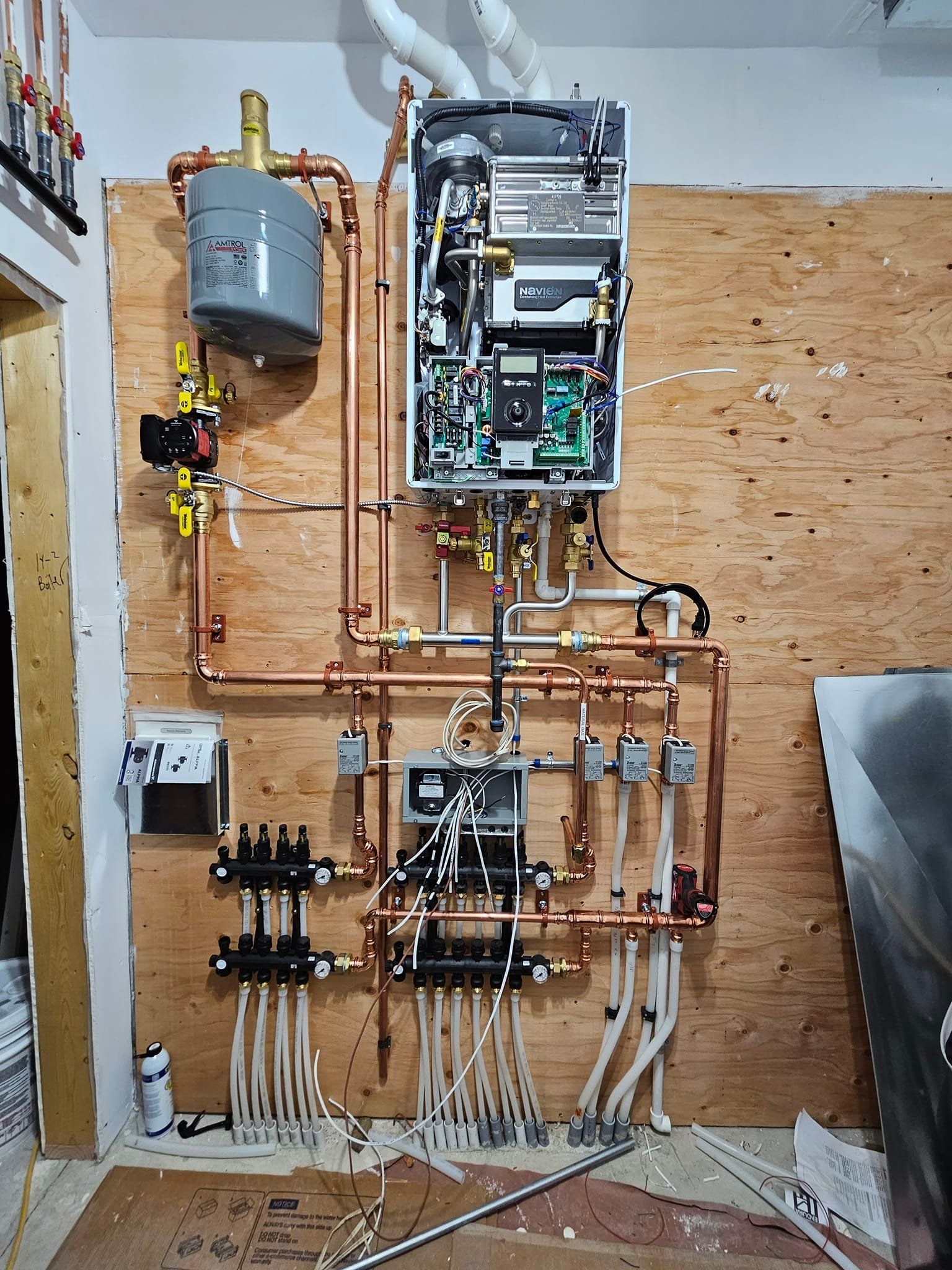A boiler is being installed on a wooden wall.
