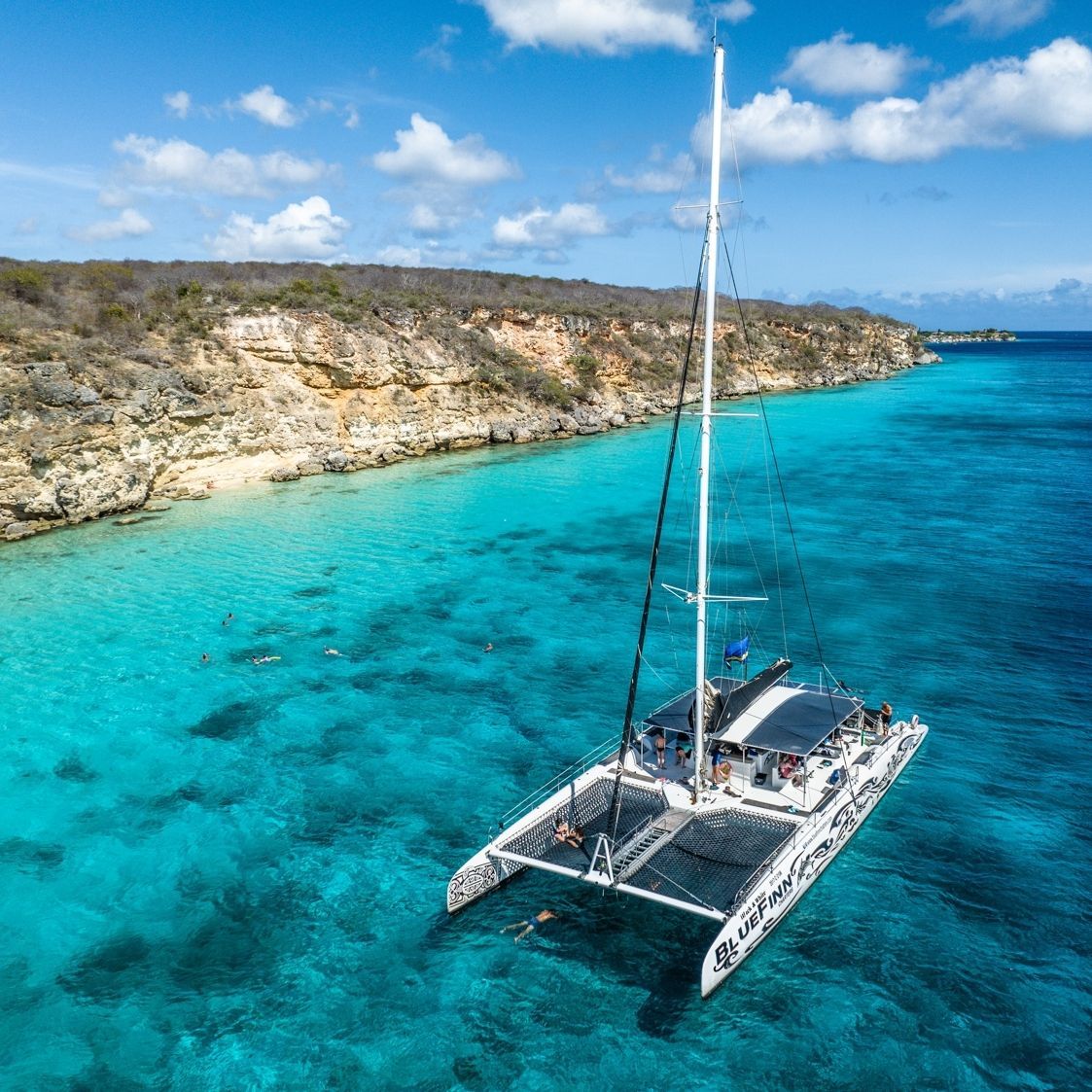 An aerial view of a sailboat in the ocean.