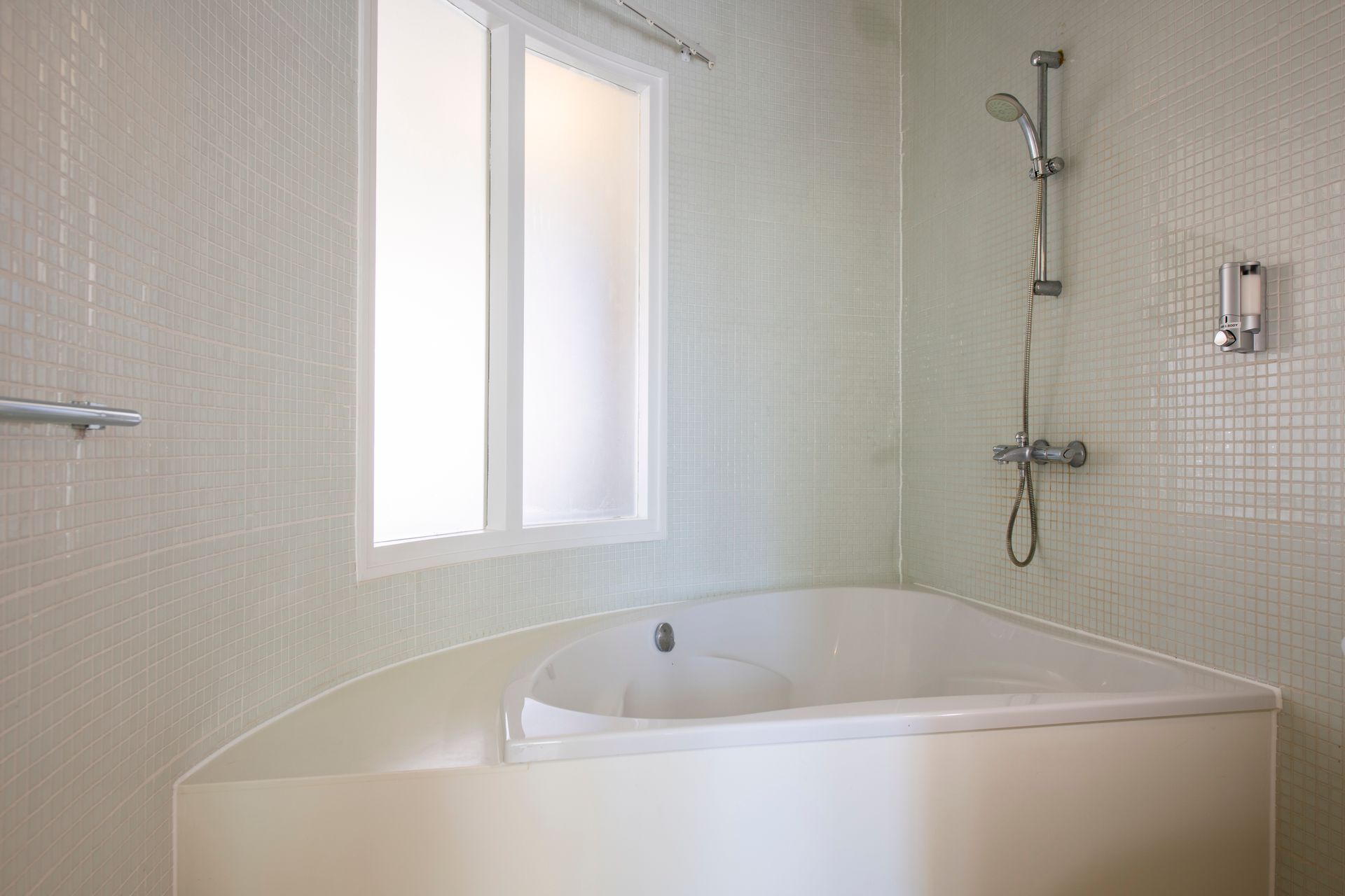 A bathroom with a bathtub and a shower.