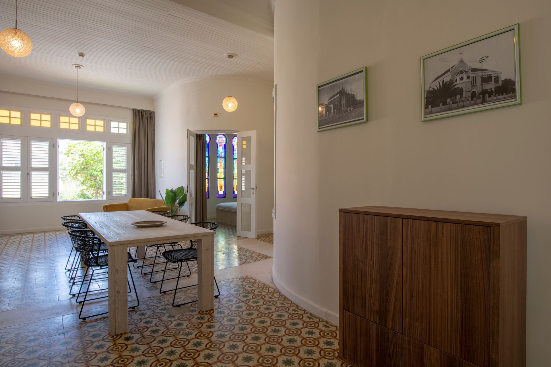 A living room with a table and chairs and a stained glass window. t Klooster Hotel Curacao