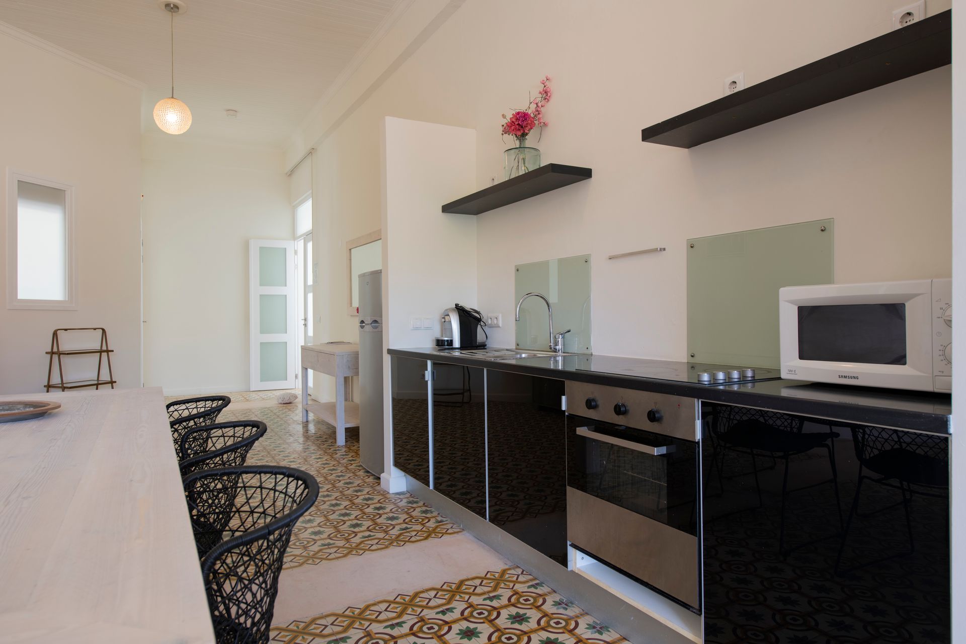A kitchen with black cabinets and a microwave oven