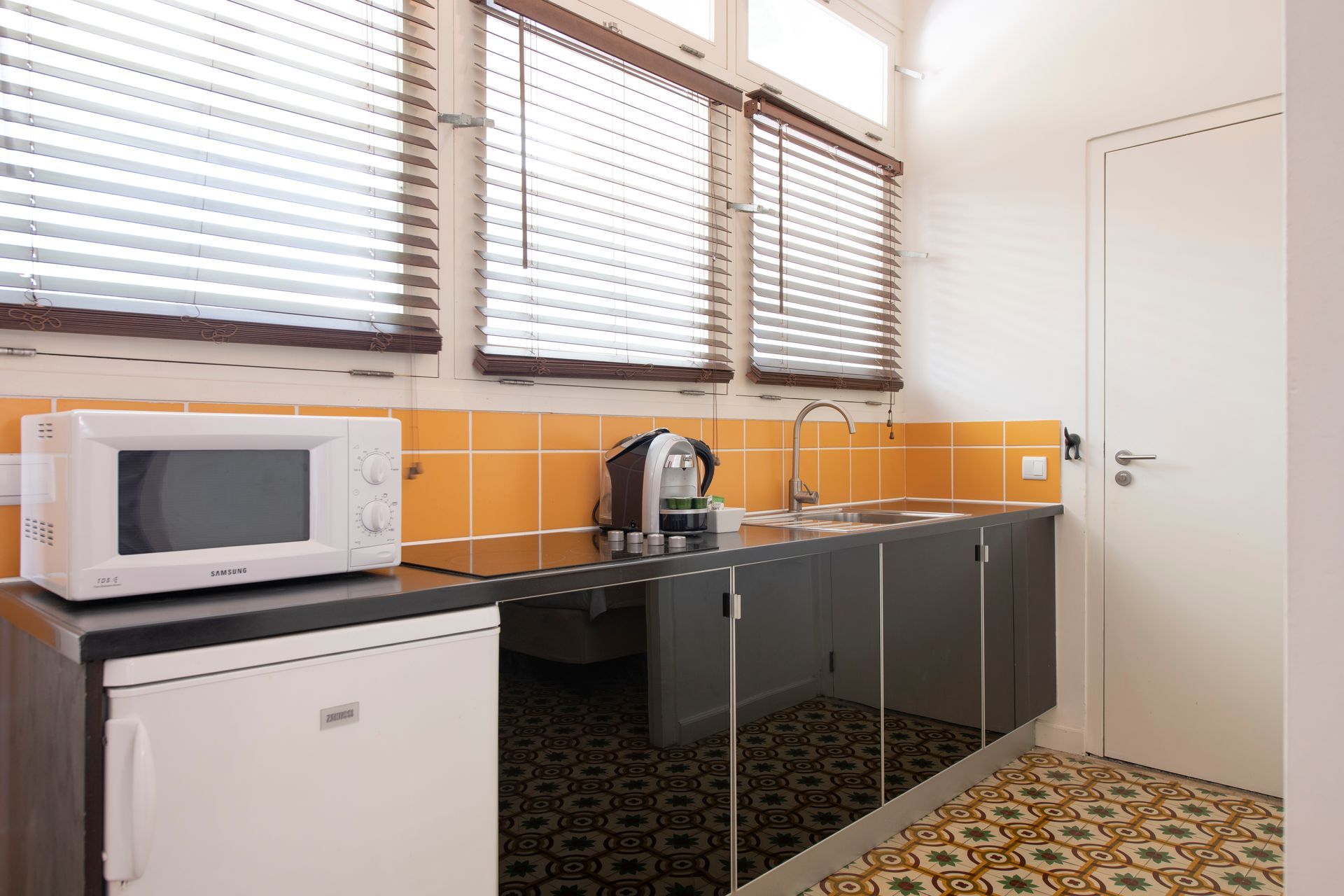 A kitchen with a microwave , refrigerator and sink.