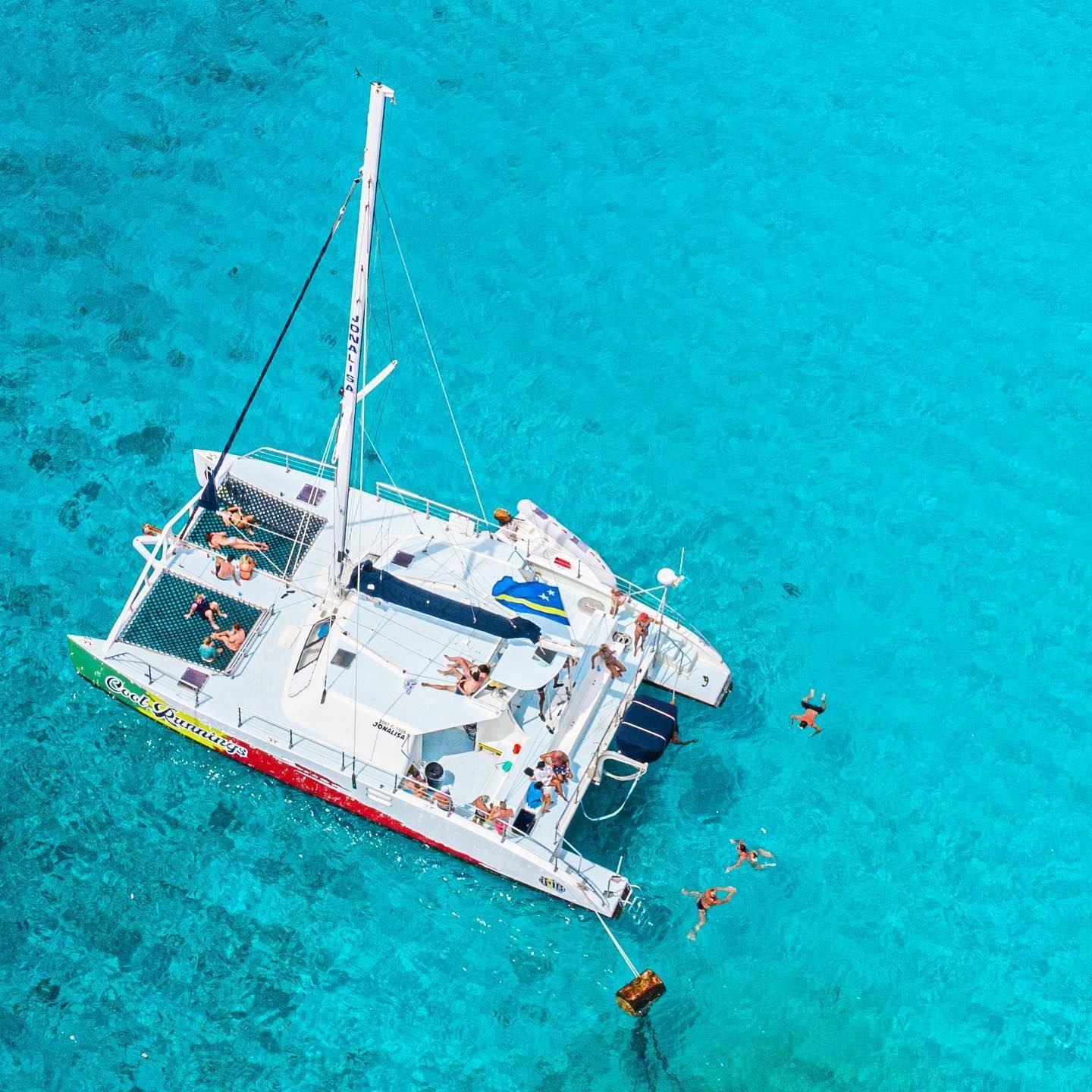 An aerial view of a sailboat in the ocean.