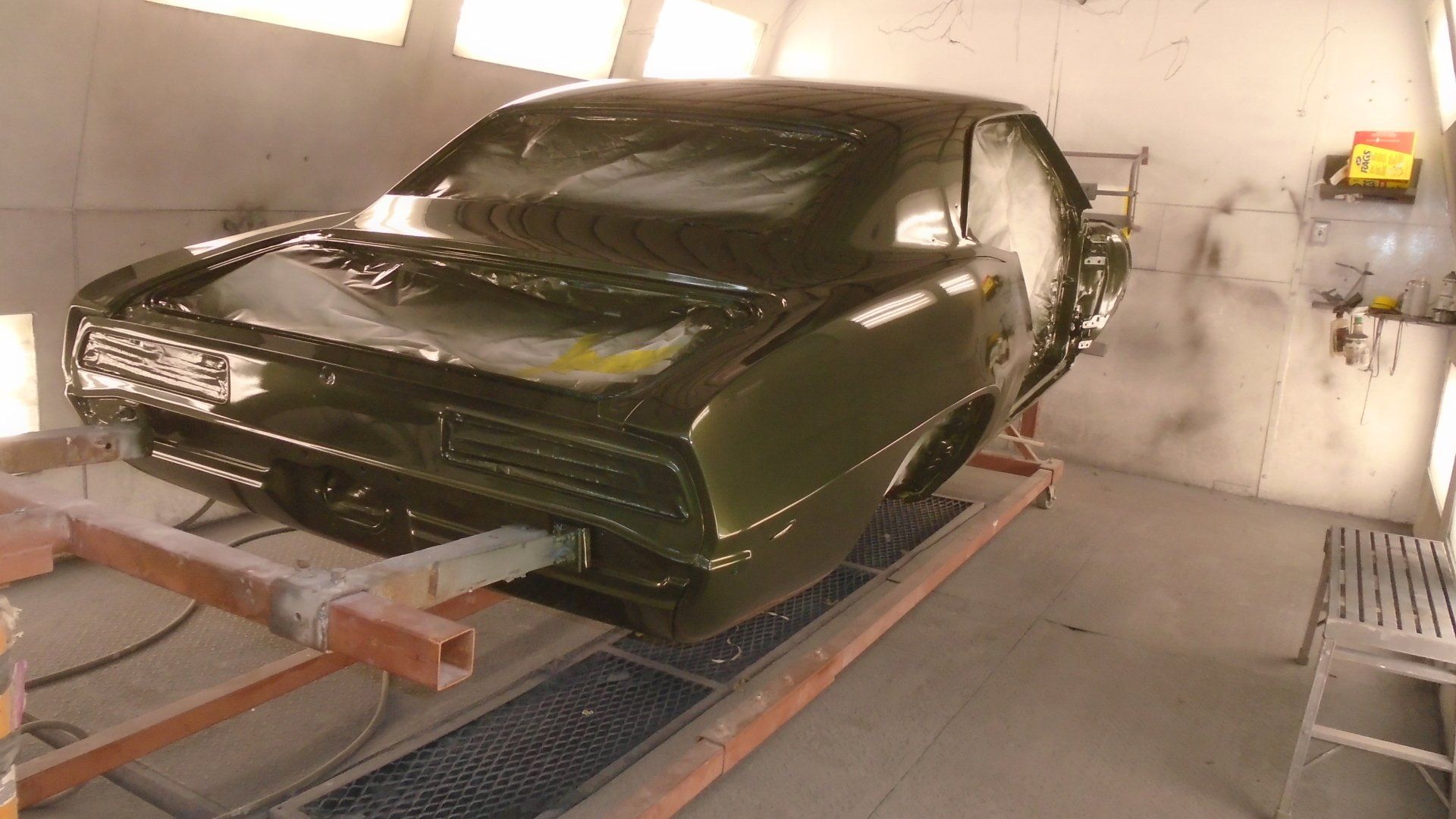 Classic green car in a paint booth.