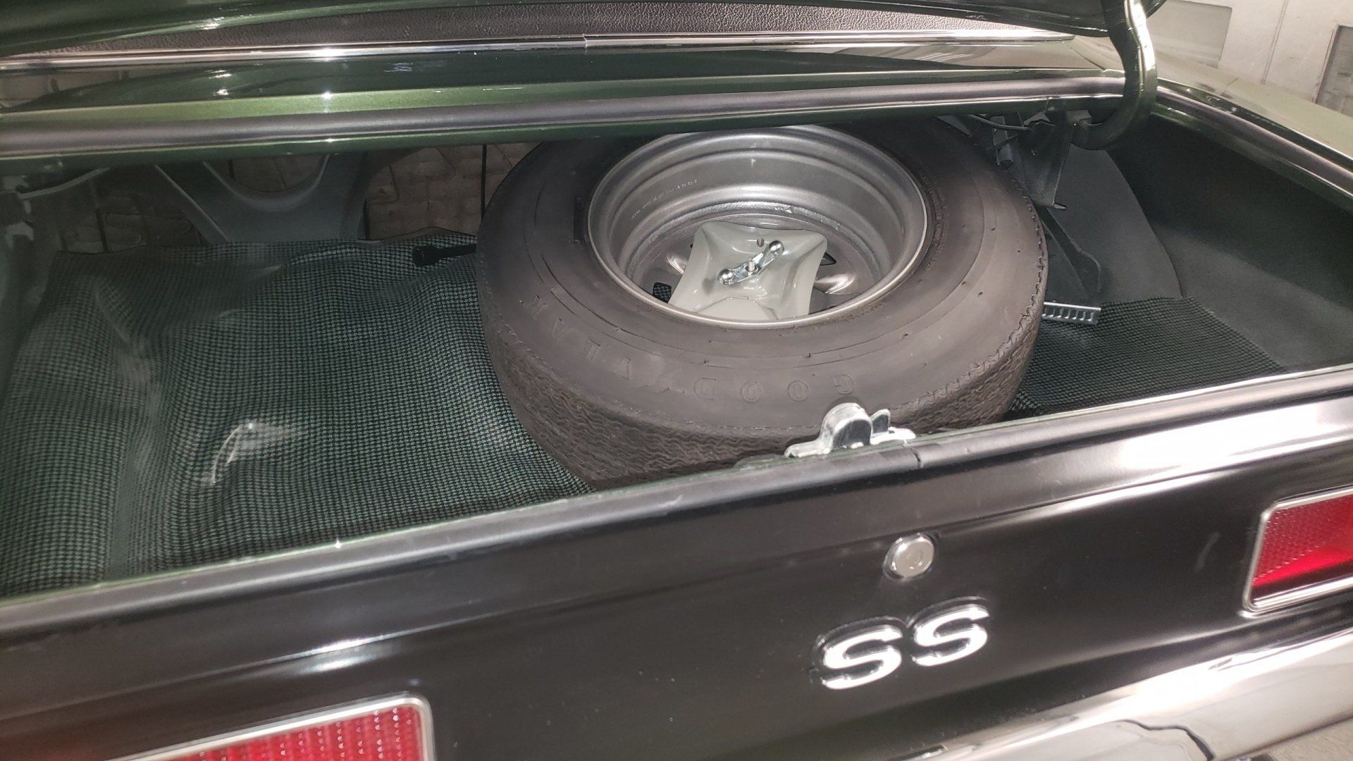 Black car trunk with a spare tire, the emblem reads 