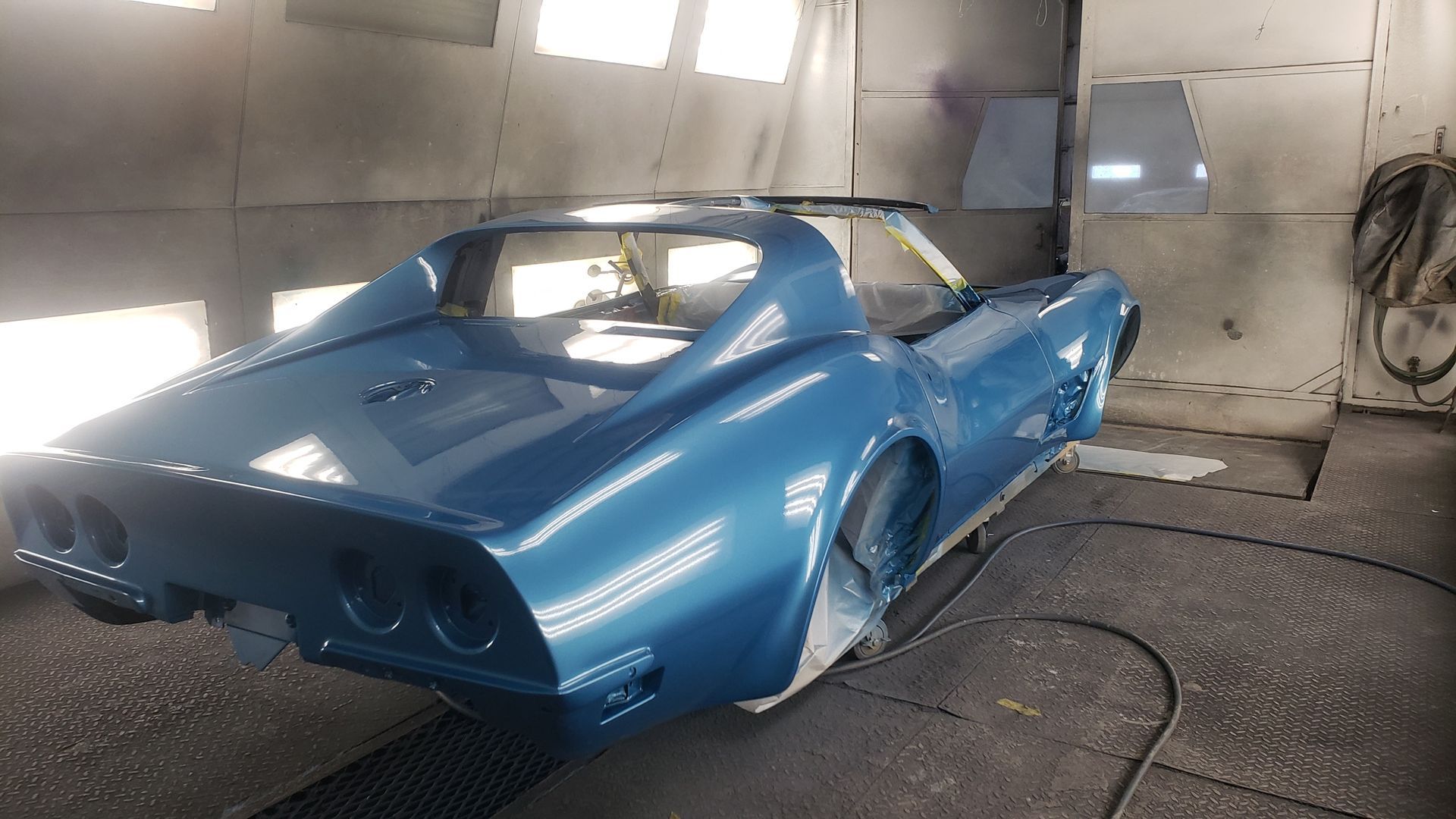 Blue classic car in a paint booth.