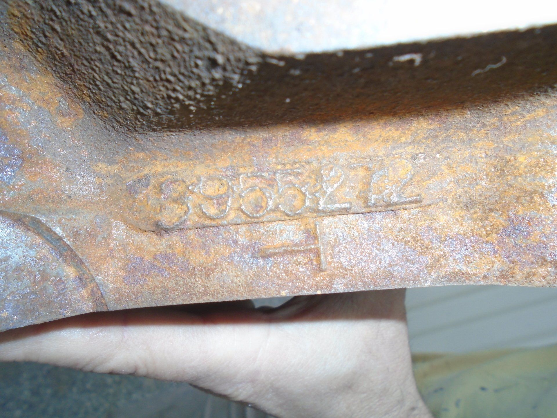 Close-up of a rusty metal frame with the stamped number 