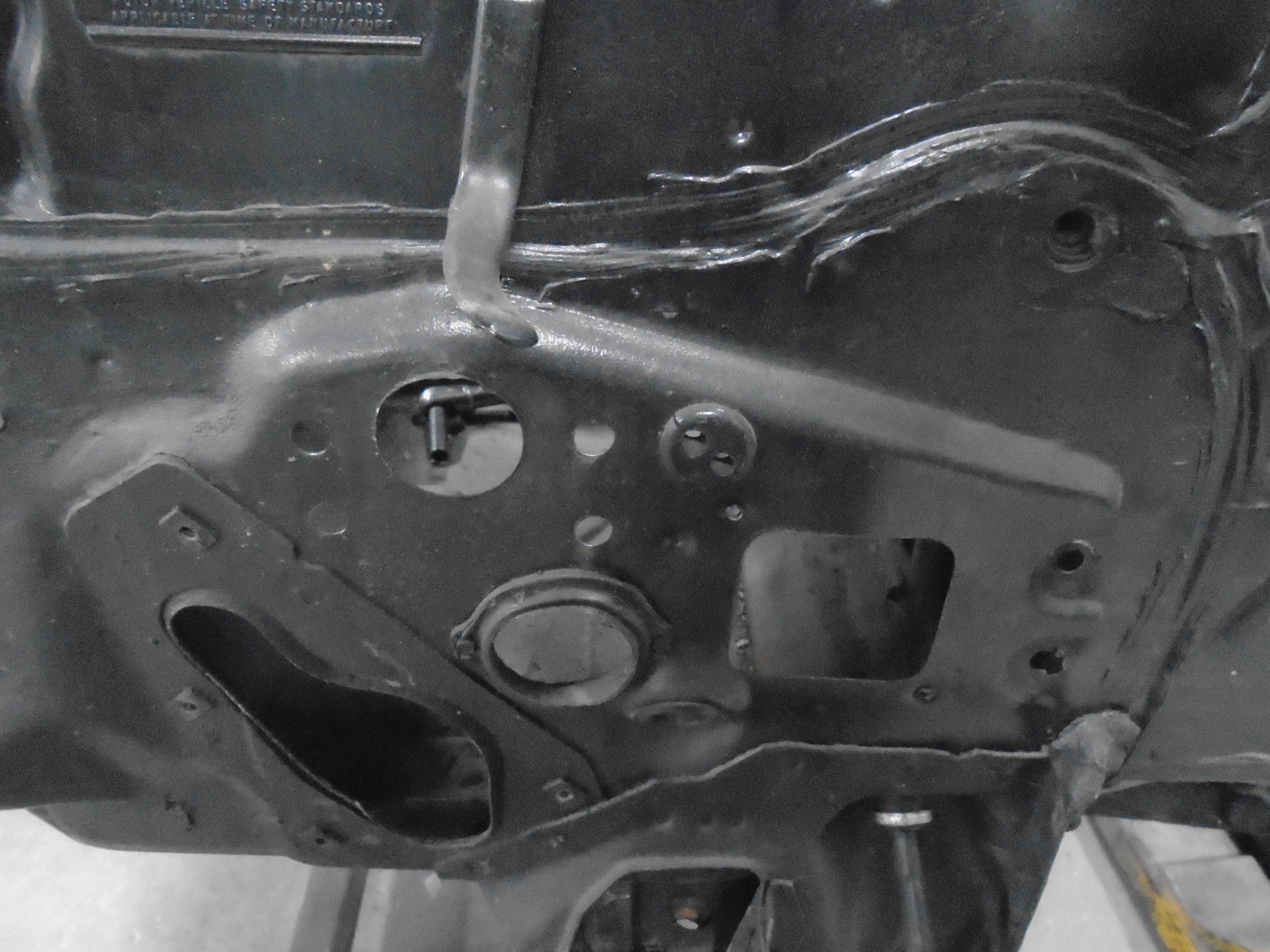 Black car firewall with holes for components.