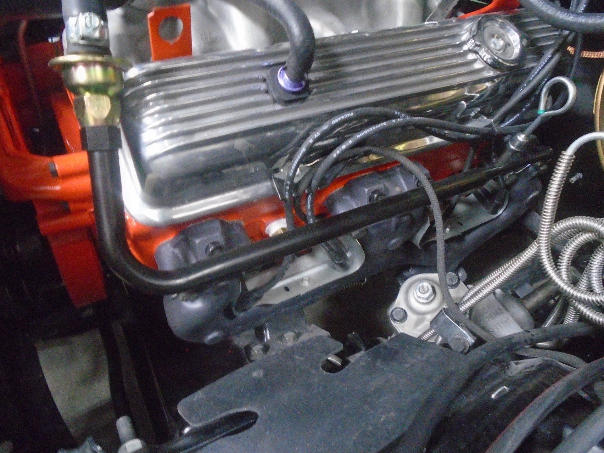 Close-up of a car engine with orange and black components.