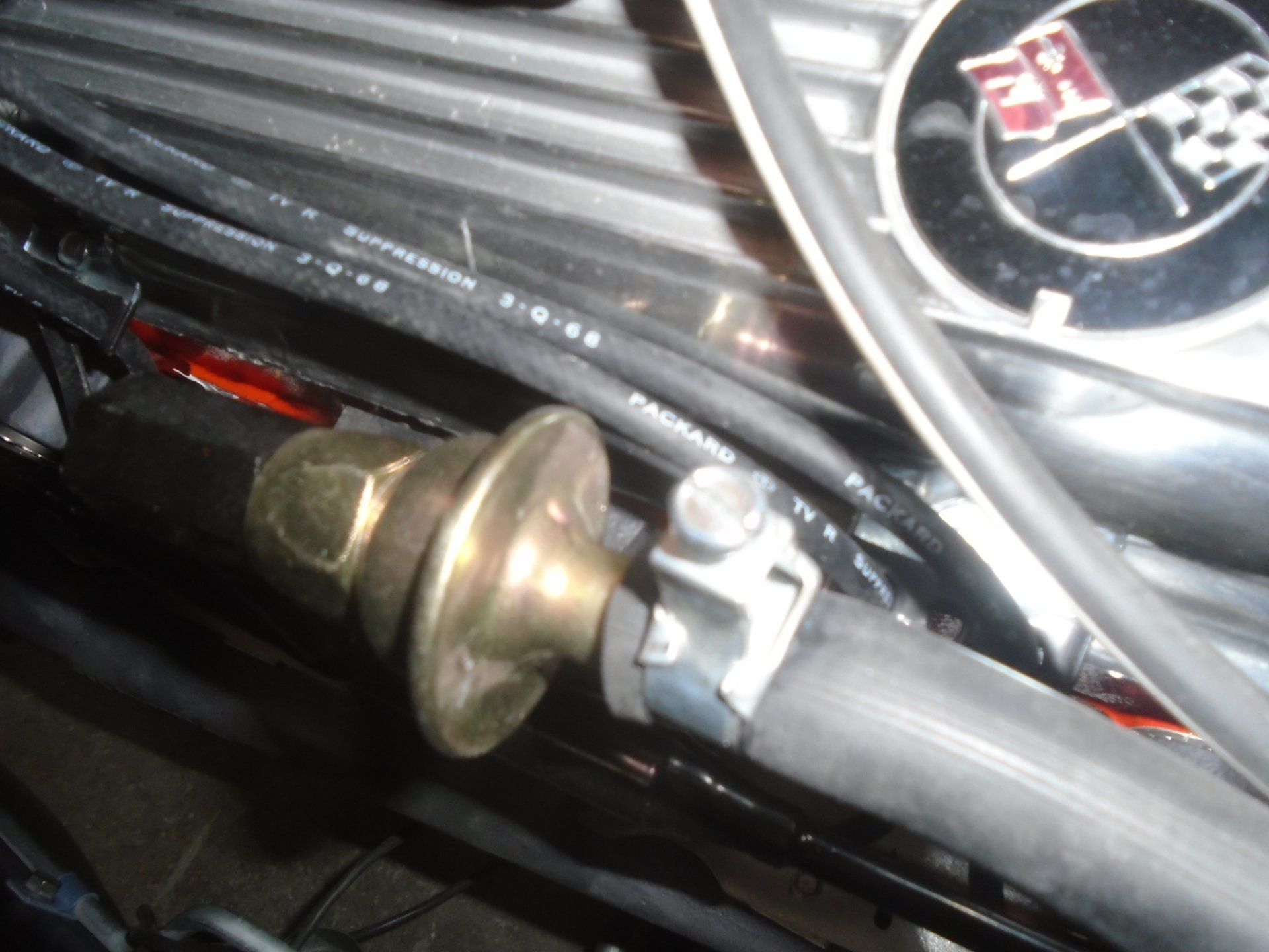 Fuel pressure regulator with a hose clamp, attached to a car engine.