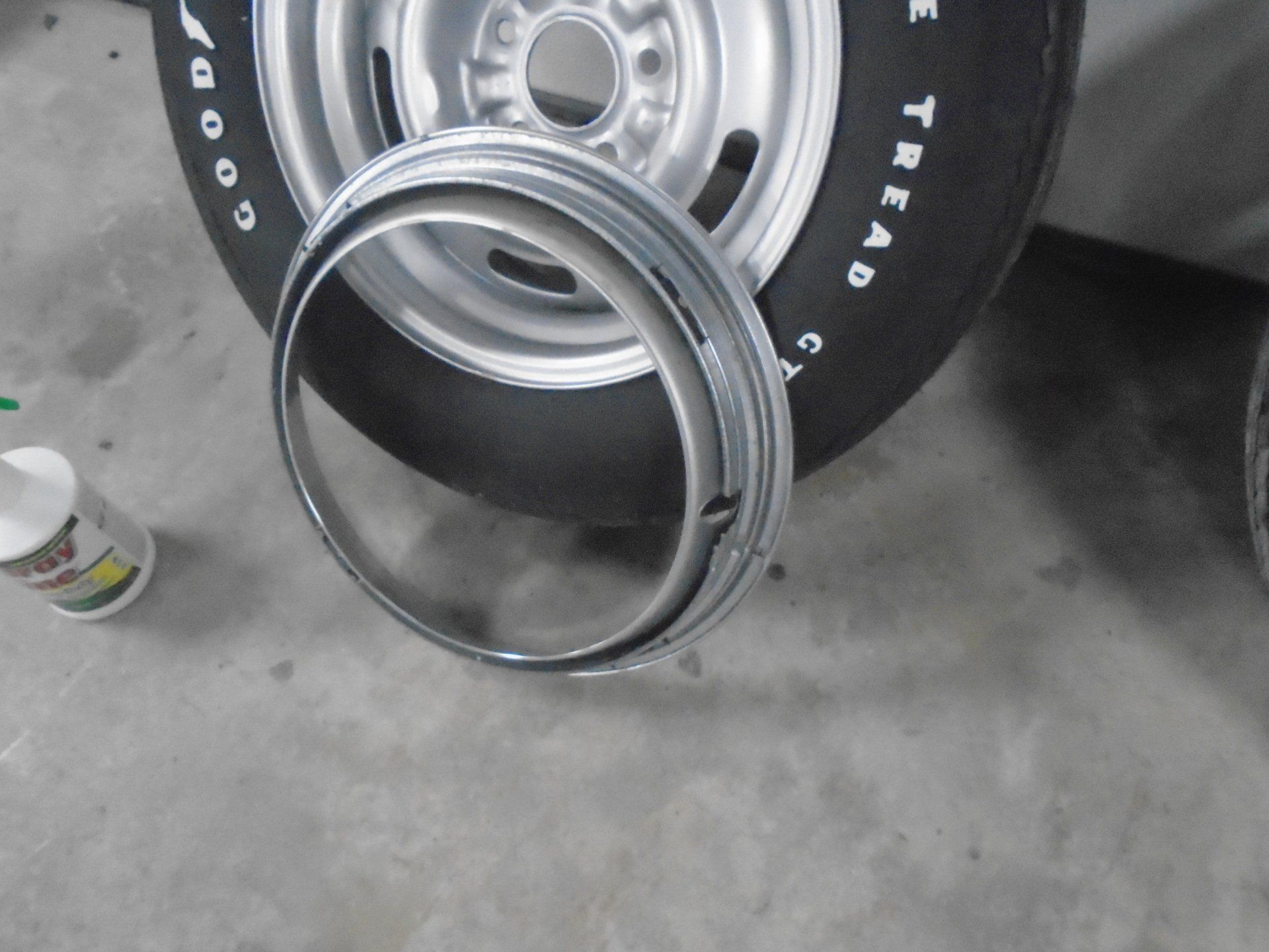 Chrome beauty ring in front of a silver wheel and black tire.