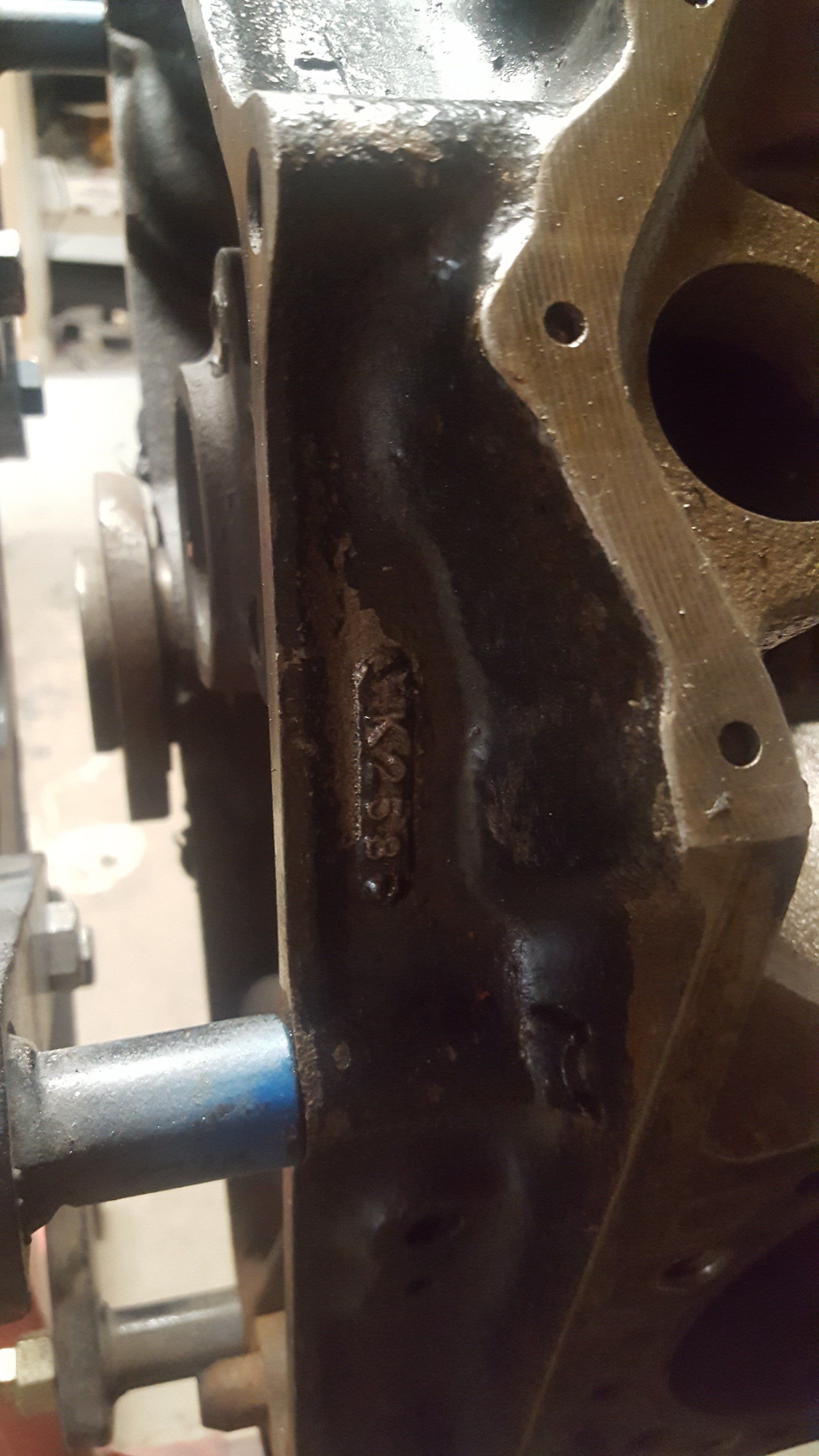Close-up of a black engine block with stamped numbers visible on the side.