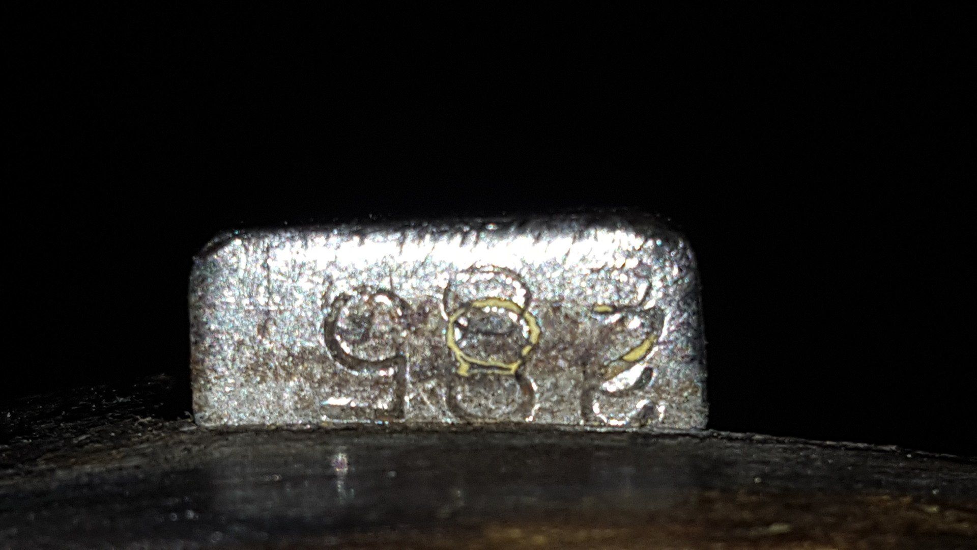 Close-up of a small, rectangular silver object with the numbers 