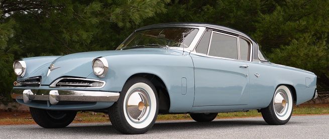 Light blue 1950s Studebaker coupe with a black roof, white-walled tires, and chrome accents.