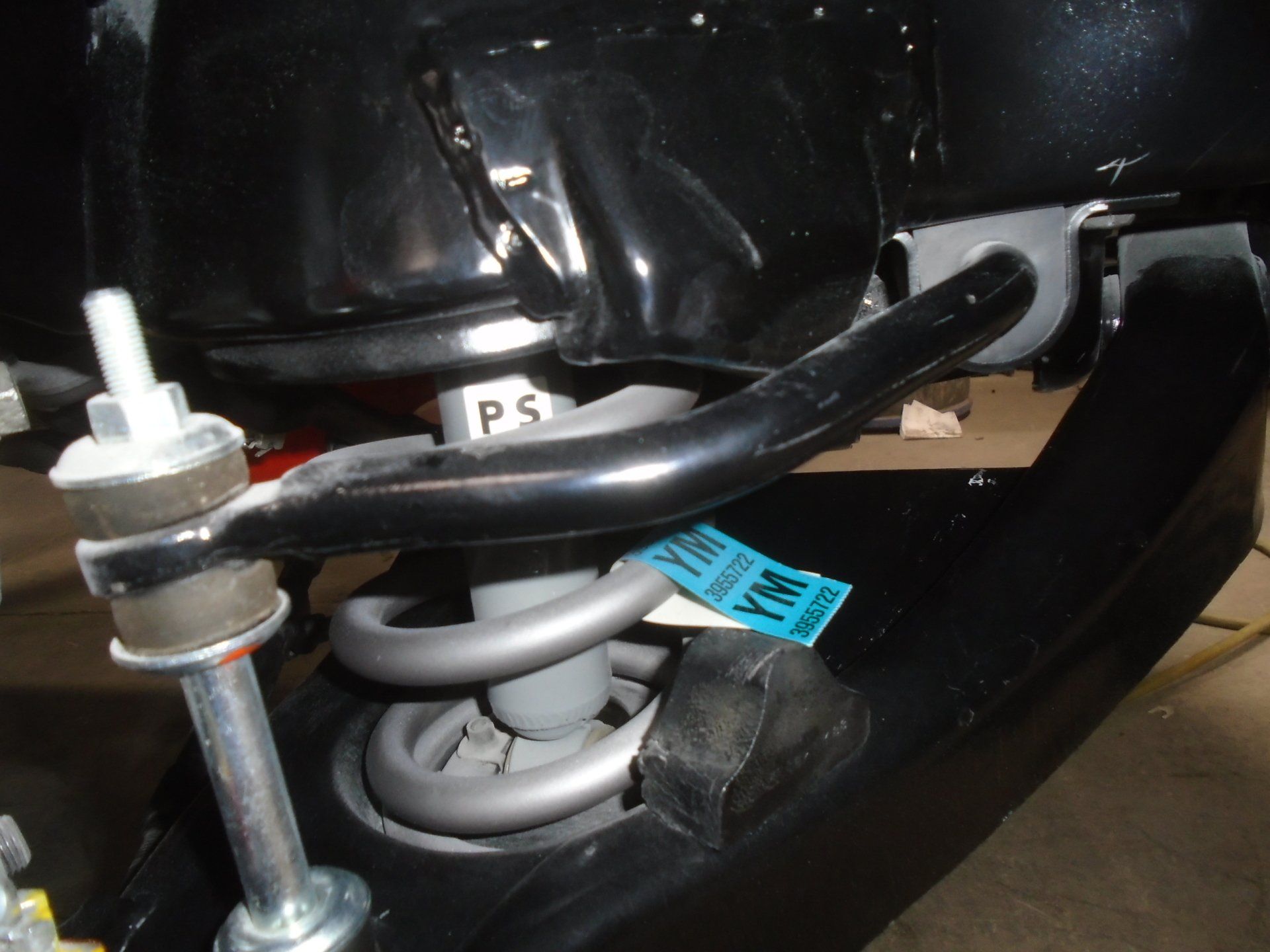 Black car suspension components: spring, shock, sway bar, and chassis.